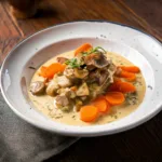 Blanquette de veau traditionnelle dans une cocotte, sauce crémeuse avec champignons et légumes